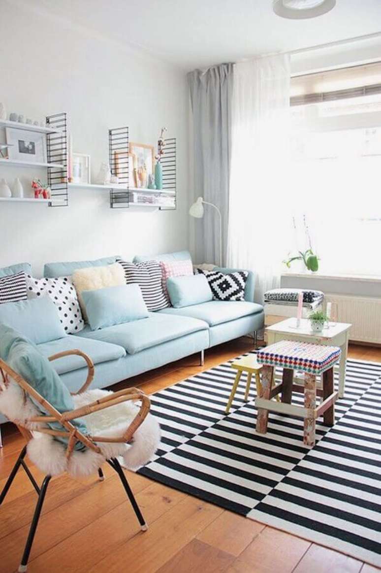 19. Decoração de sala de visita branca com sofá azul claro e tapete listrado preto e branco – Foto: Apartment Therapy