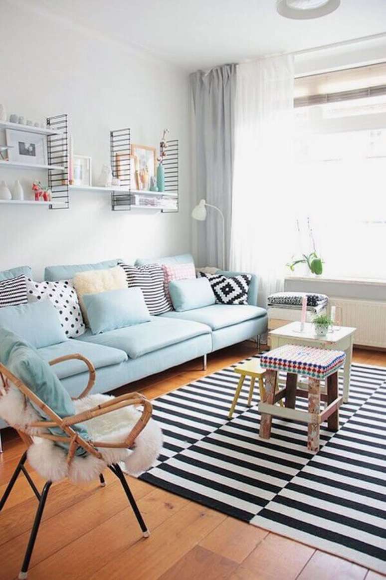 19. Decora&ccedil;&atilde;o de sala de visita branca com sof&aacute; azul claro e tapete listrado preto e branco &ndash; Foto: Apartment Therapy