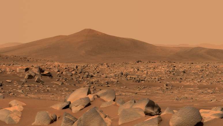 Esta imagem mostra Santa Cruz, uma colina a cerca de 1,5 milhas (2,5 km) de distância do rover. A cena inteira está dentro da cratera Jezero de Marte; a borda da cratera pode ser vista na linha do horizonte além da colina.