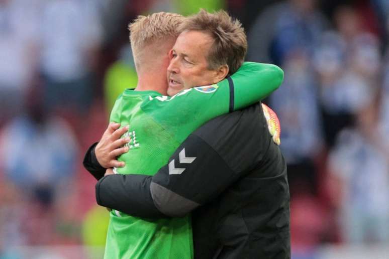 Kasper Hjulmand abrançando o goleiro Kasper Schmeichel após lance de Eriksen (Foto: HANNAH MCKAY/POOL/AFP)