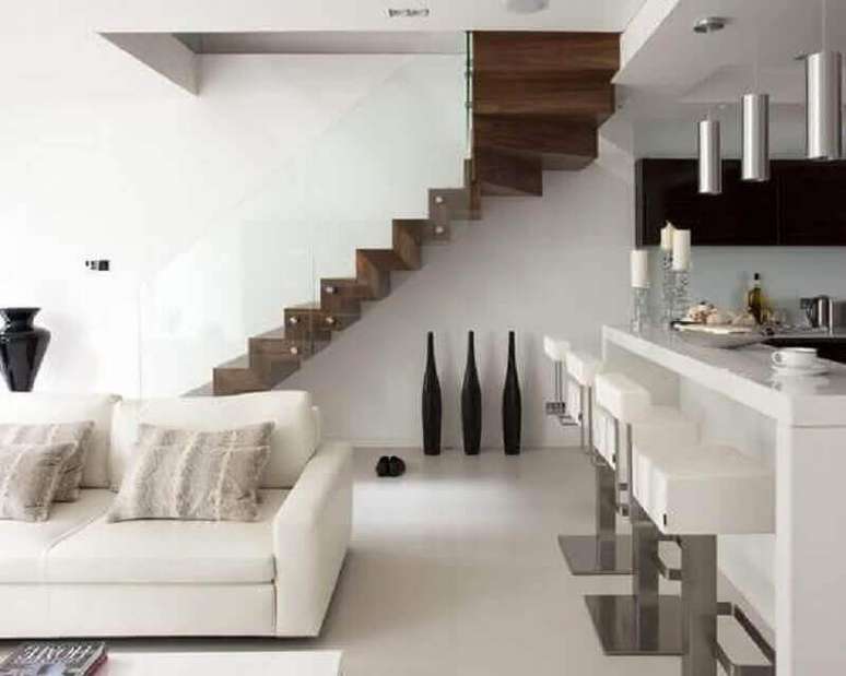 11. Sala branca decorada com escada interna de madeira em L – Foto: Pinterest