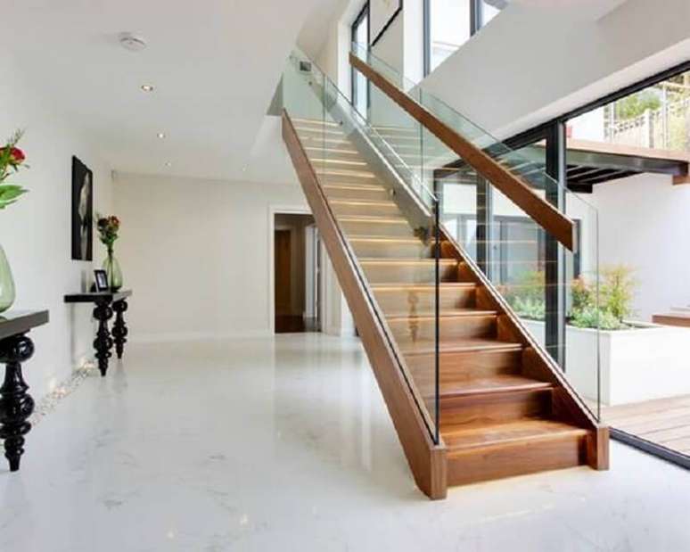 44. Decoração sofisticada para casa branca com escada de madeira interna com guarda corpo de vidro – Foto: Pinterest