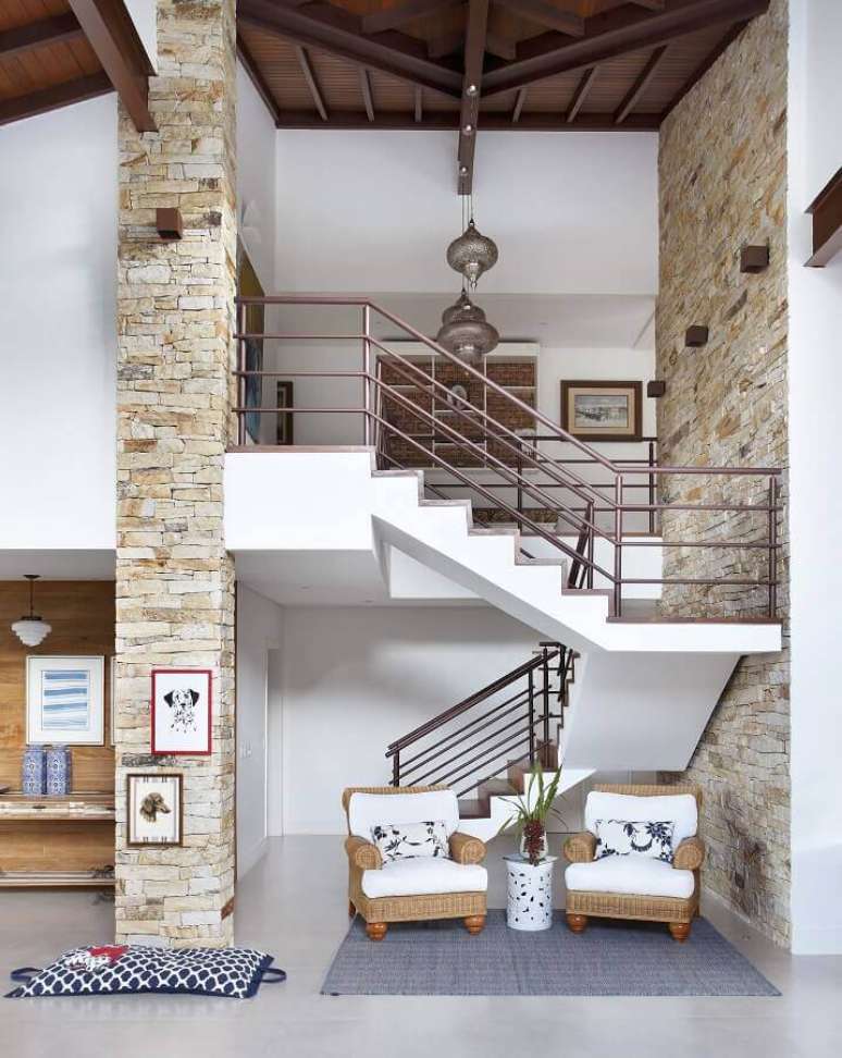 62. Sala de visita decorada com revestimento de parede r&uacute;stico e escadas internas em U &ndash; Foto: RBP Arquitetura e Interiores