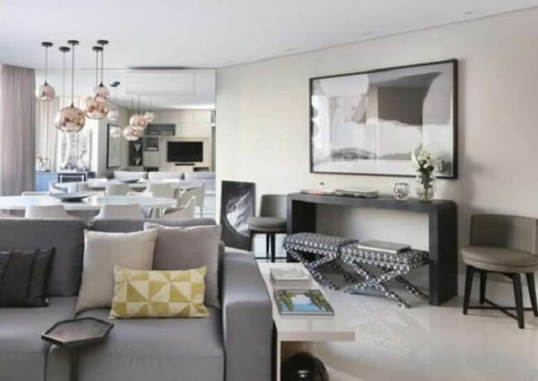 33. Aproveite o espa&ccedil;o livre para incluir um lindo aparador preto para sala. Fonte: Simone Saccab