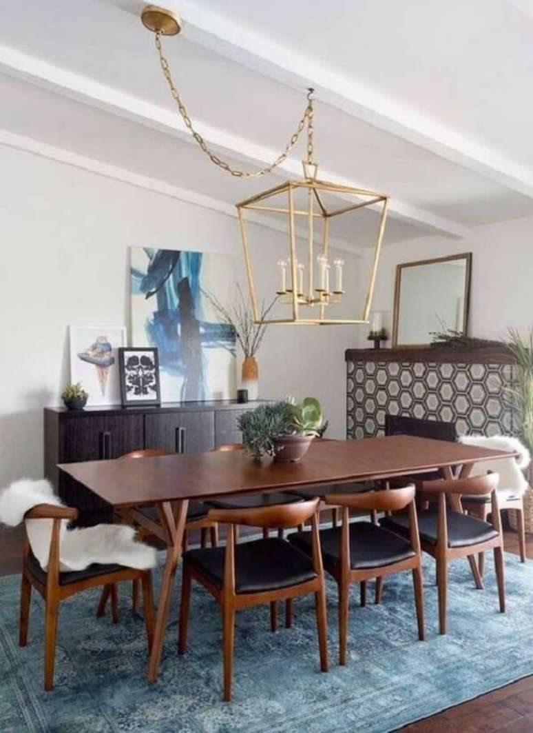 1. Sala de jantar aconchegante com mesa de madeira e aparador buffet preto. Fonte: Revista Viva Decora 2