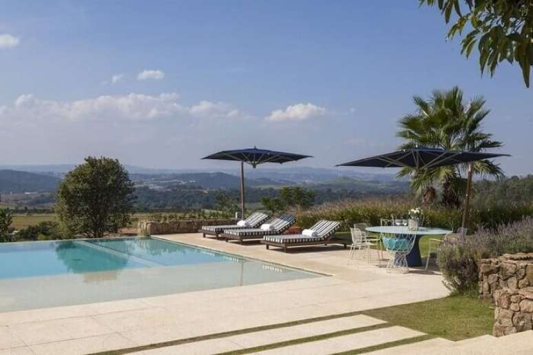 11. A piscina grande de alvenaria deixa a &aacute;rea externa ainda mais bonita. Projeto por In House