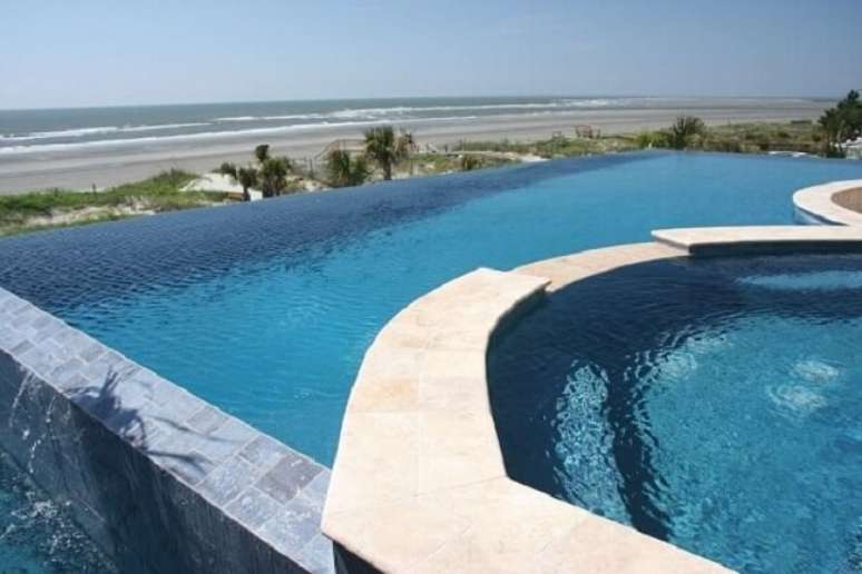 37. Piscina grande com borda infinita que se interliga a outra piscina do ambiente. Fonte: Total Constru&ccedil;&atilde;o