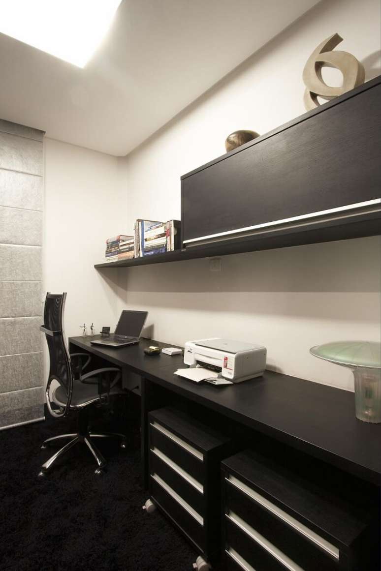 31. Home office sofisticado com bancada ampla e gaveteiro preto. Projeto de Léo Shehtman