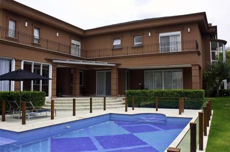 22. Foto de piscina grande com guarda corpo de vidro e madeira. Projeto de F&aacute;bio Morozini