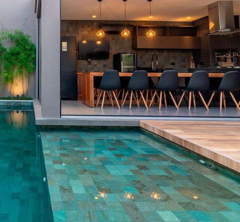 30. Modelos de área gourmet com piscina decorada com cadeiras pretas – Foto: Pinterest