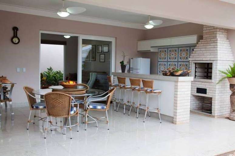 39. Modelos de área gourmet externa grande decorada com mesa redonda e churrasqueira de tijolinho – Foto: Fantin Siqueira