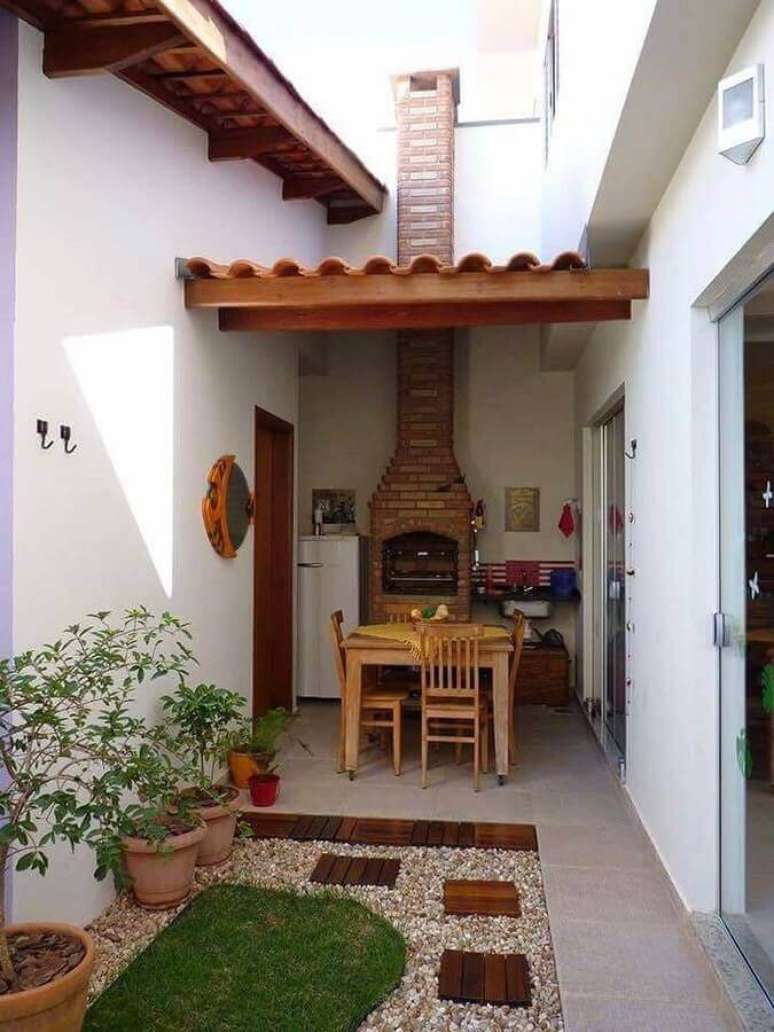 9. Área gourmet externa decorada com churrasqueira de tijolinho e jardim de pedras – Foto: SOS Reforma e Construção