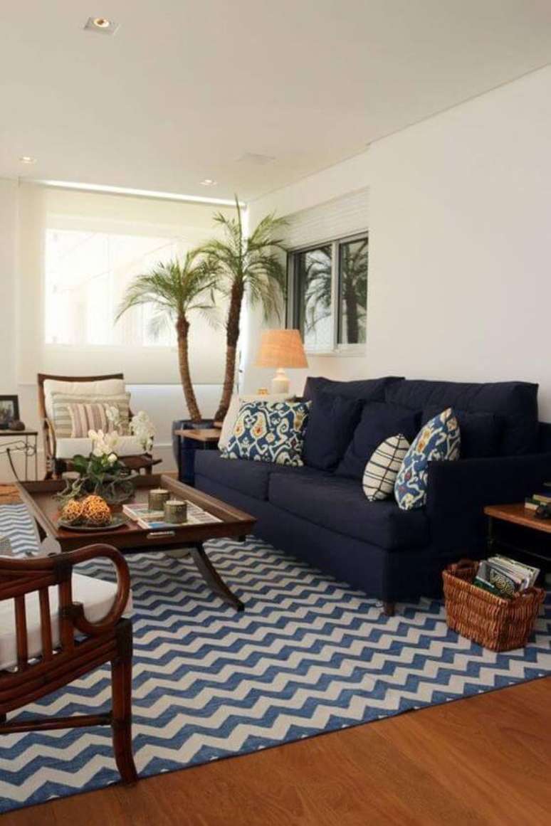 32. Tapete chevron em tons de azul e sofá azul marinho com móveis de madeira na sala -Foto Pinterest