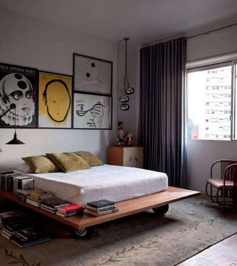 42. Quadros para quarto de homem decorado com cama baixa de madeira – Foto: Pinterest