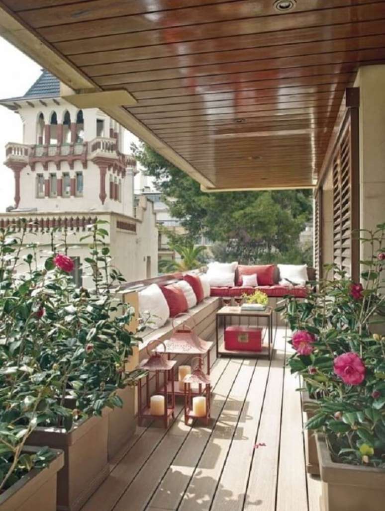 35. Flores e móveis rústicos para sacada com deck de madeira -Fonte Pinterest