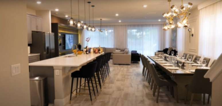 Sala compartilhada com a cozinha e mesa de 14 lugares (Foto: Reprodução)