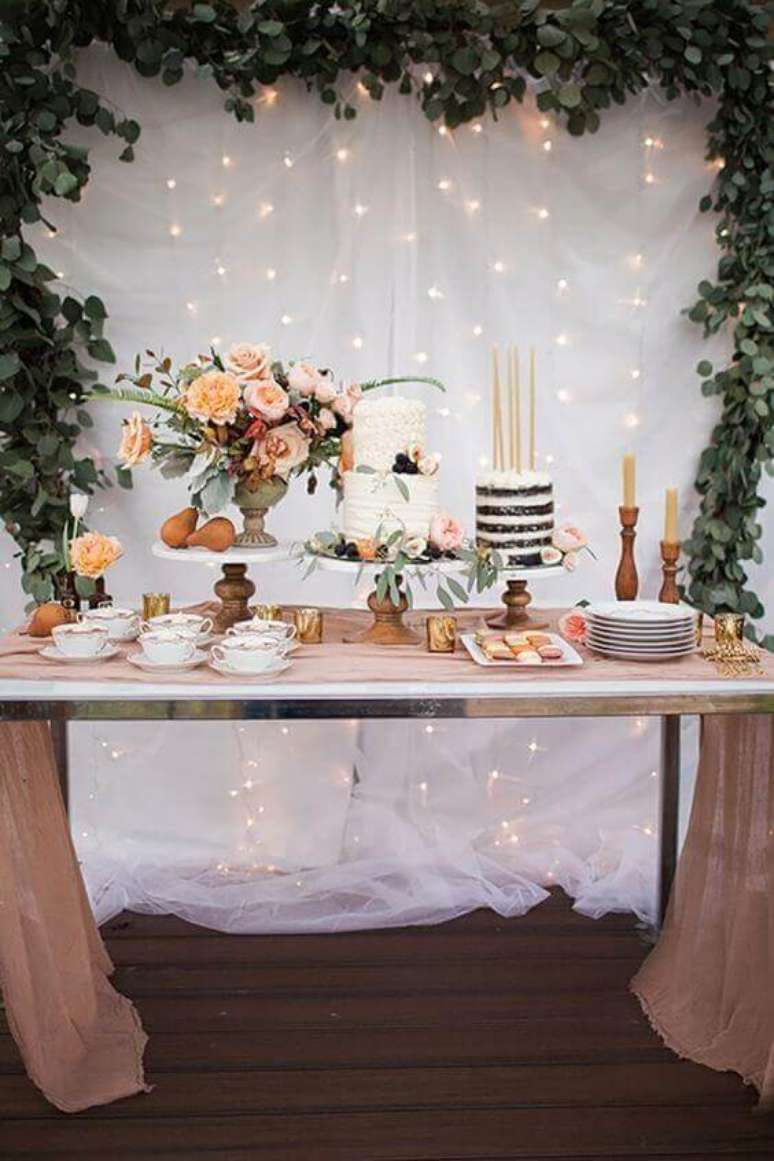 36. A iluminação com luzinhas no painel da mesa de bolo deu um toque mais charmoso à decoração mini wedding – Foto: Postable