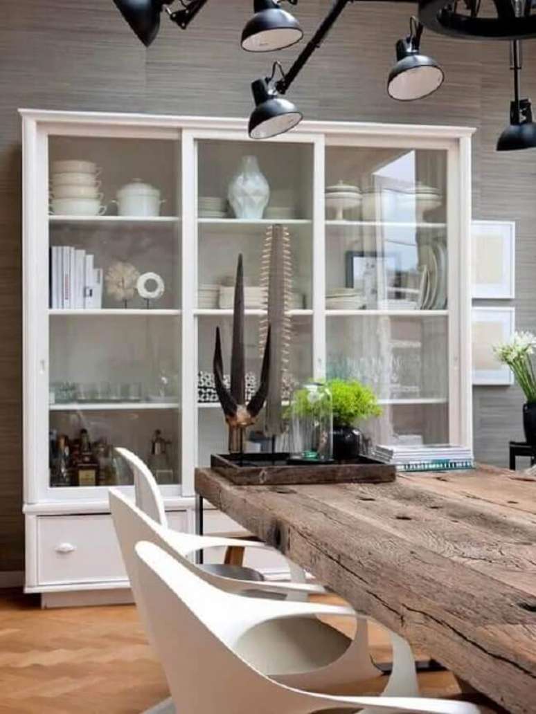 32. Decora&ccedil;&atilde;o para sala de jantar com cristaleira de branca e mesa r&uacute;stica. Fonte: BravaCasa