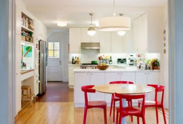 47. Cozinha americana em L com mesa redonda e cadeiras vermelhas – Foto Pinterest