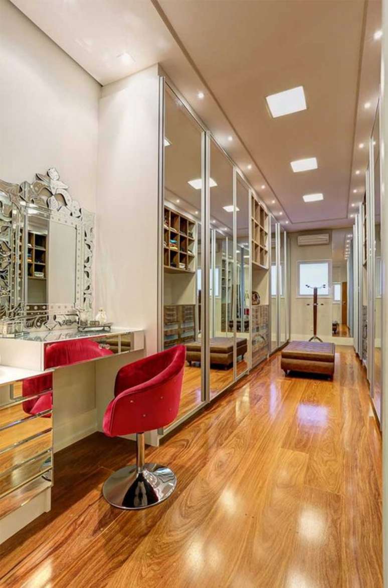 42. Cadeira vermelha giratória para penteadeira espelhada no closet planejado – Foto Decor Salteado