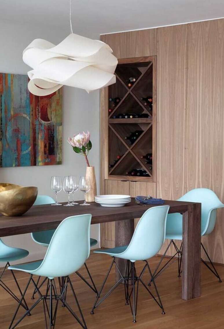 51. Lustre de teto para sala de jantar decorada com mesa de madeira e cadeiras azuis – Foto: Pinterest