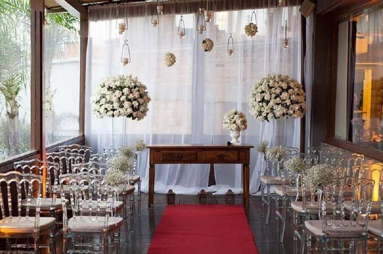 25. Cerimônia de casamento mini wedding decorada com cadeiras de acrílico transparente e arranjo de rosas brancas – Foto: Party Style