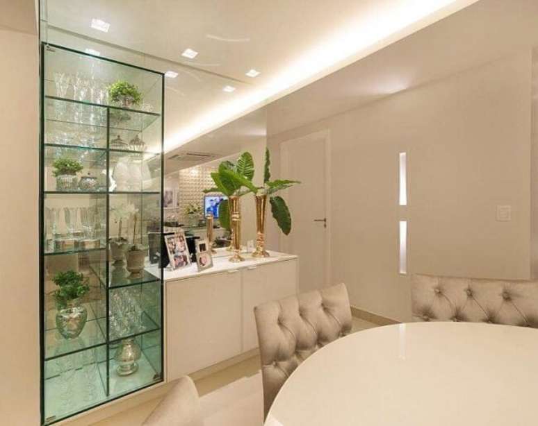 48. A cristaleira branca com prateleiras assim&eacute;tricas garantem visual sofisticado ao espa&ccedil;o. Fonte: FM Arquitetura