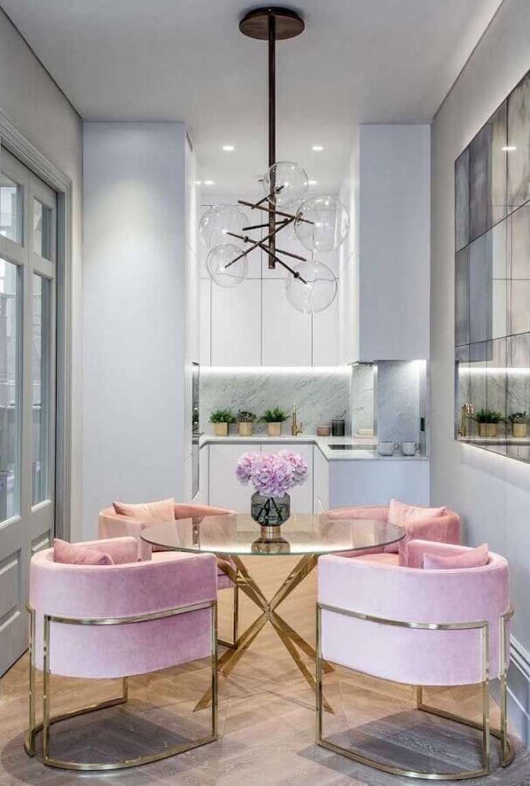 52. Lustre de teto para sala de jantar decorada com mesa de vidro e cadeiras estofadas cor de rosa – Foto: Apartment Therapy