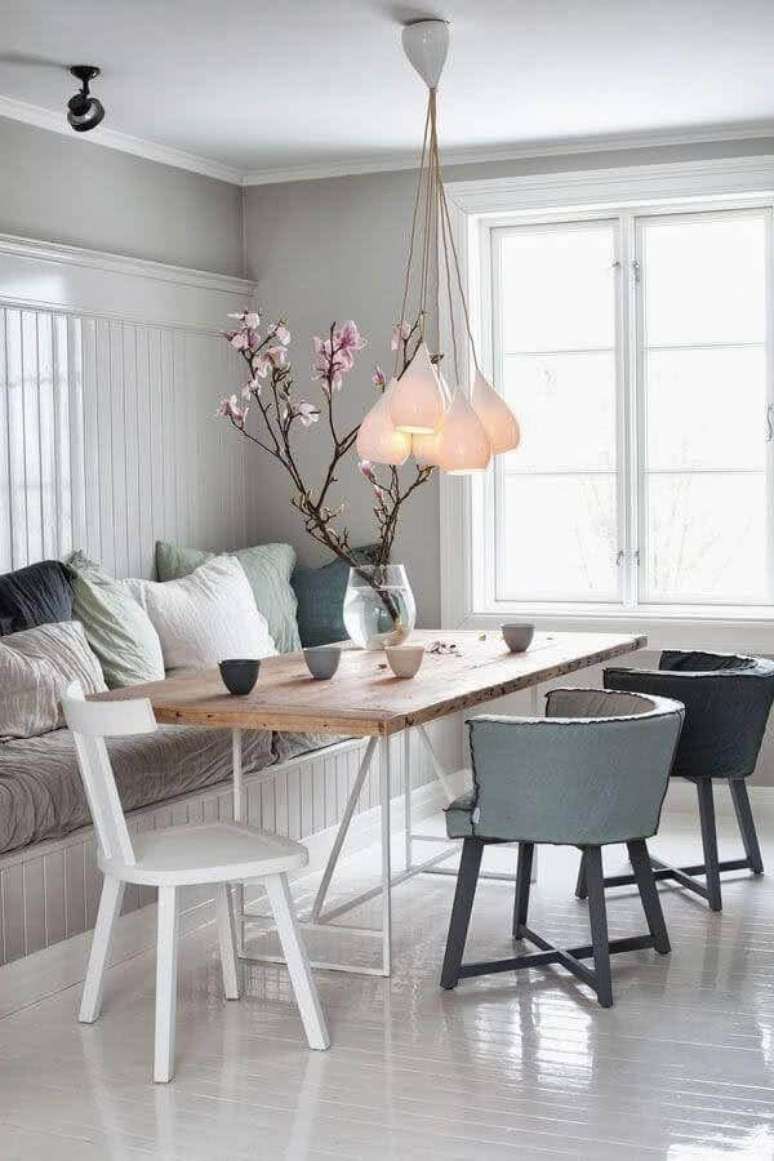 48. Lustre de teto para sala de jantar branca decorada com várias almofadas – Foto: Pinterest