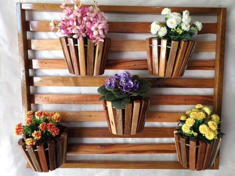 35. Floreira de madeira sustenta cinco vasos de flores. Fonte: Pinterest