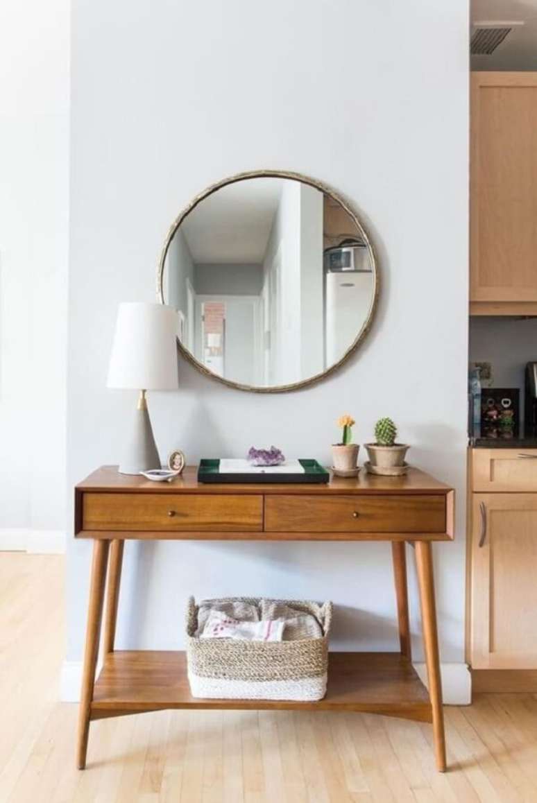 29. Espelho redondo e aparador para sala pé palito decoram o cômodo. Fonte: Pinterest