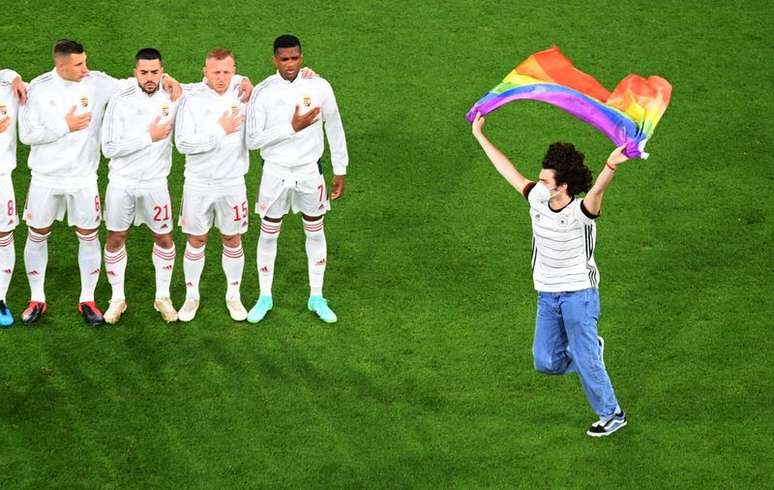 Ein Demonstrant schwenkt vor dem Spiel Deutschland-Ungarn eine Regenbogenfahne 23.06.2021 via Reuters/Matthias Hangst