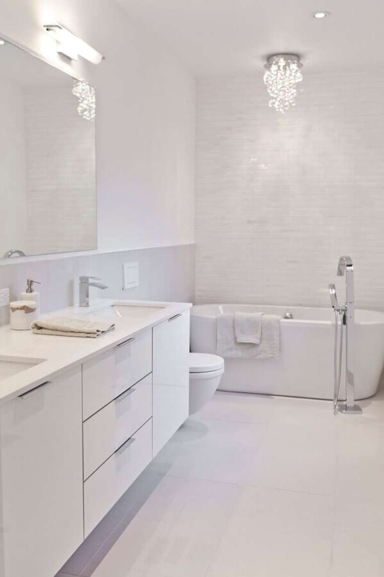 32. Banheiro com banheira decorado com armário branco – Foto: Houzz