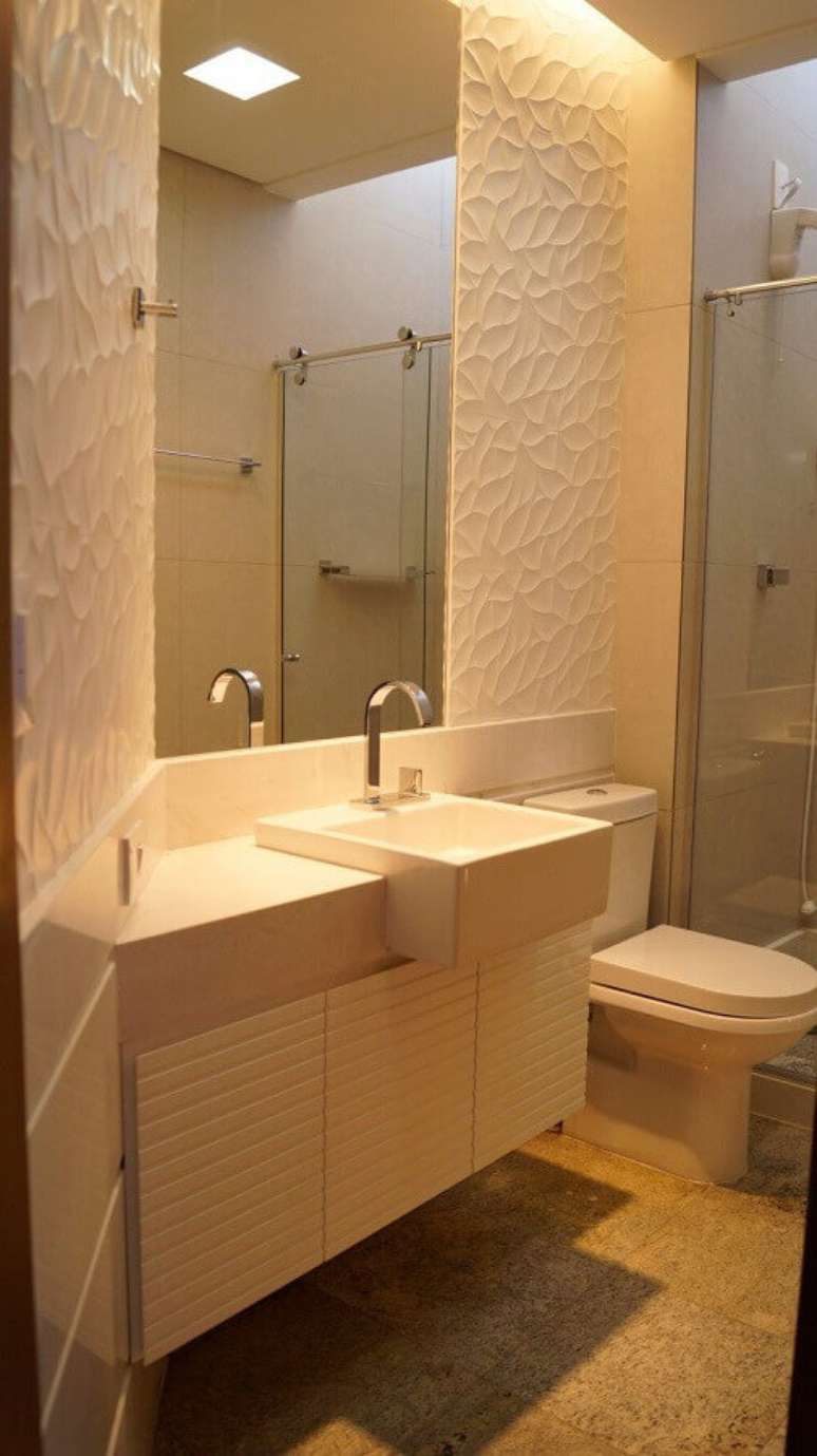 20. Armário branco de banheiro pequeno decorado com revestimento 3D – Foto: Pinterest