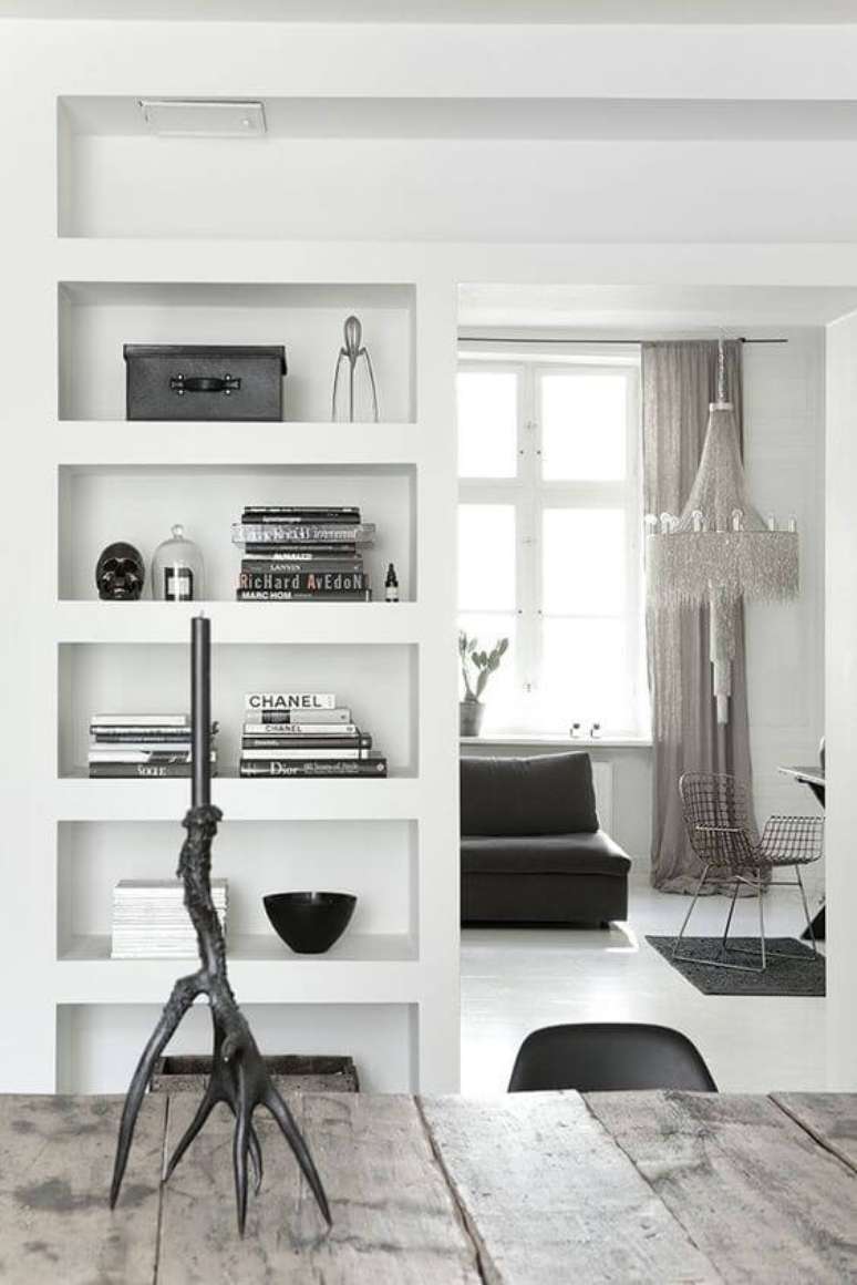 17. Sala de jantar com estante de gesso branca e decoração preta – Foto Pinterest