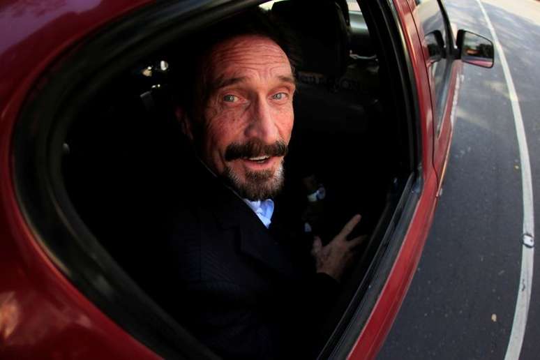 John McAfee sendo escoltado por autoridades de imigração e conduzido a aeroporto na Guatemala 12/6/2012  REUTERS/Jorge Dan Lopez