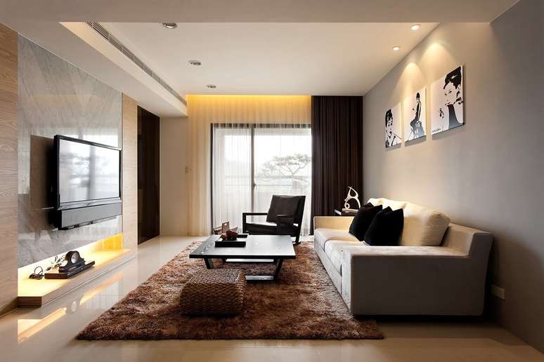 72. Sala de estar aconchegante com tons de marrom no tapete, puff e cortina – Foto Pinterest