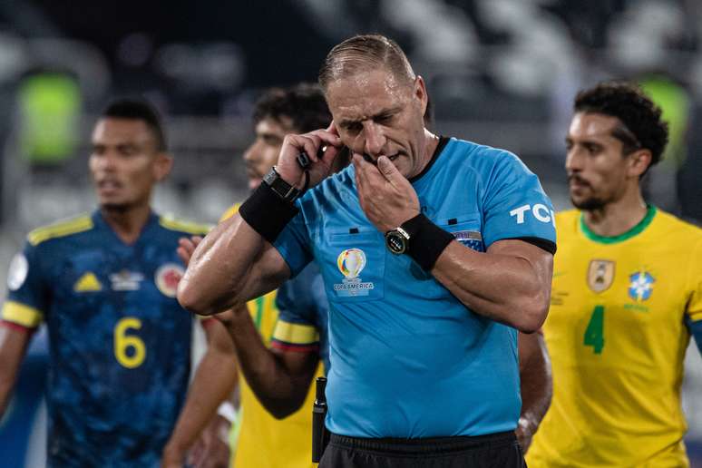 Nestor Pitana conversa com o VAR durante a partida entre Brasil e Colômbia