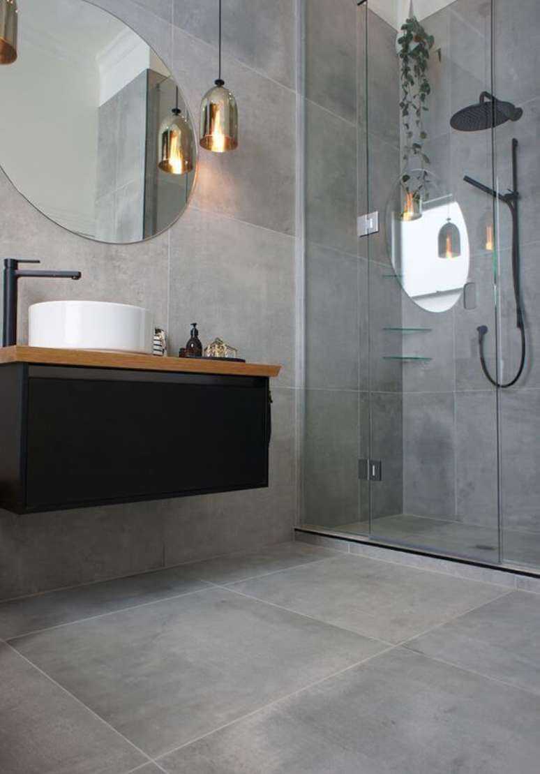 31. Porcelanato para banheiro cinza com gabinete preto – Foto Revista VD