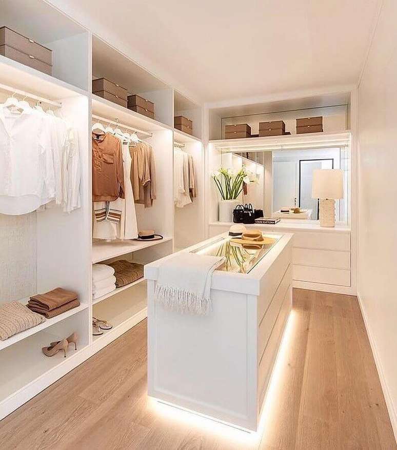 3. Armário closet aberto clean decorado com ilha com iluminação – Foto: Dicas de Mulher