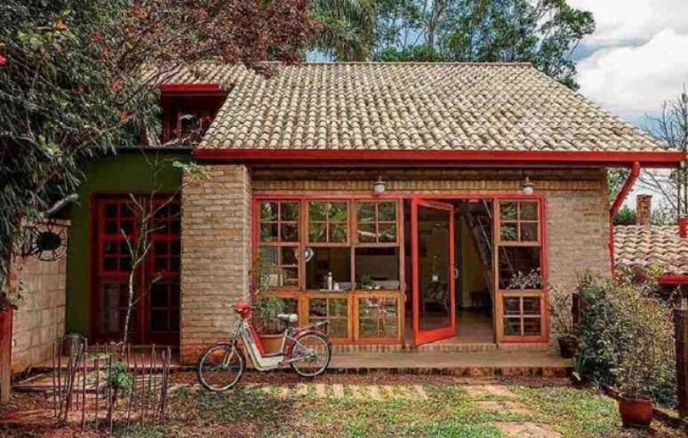 61. O toque em vermelho traz um charme especial para a fachada com revestimento externo em tijolinho. Fonte: Pinterest