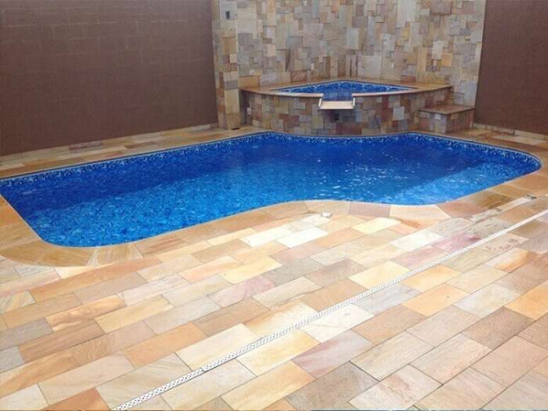 20. A pedra S&atilde;o Tom&eacute; usada como revestimento externo de piso na &aacute;rea da piscina. Fonte: Pinterest