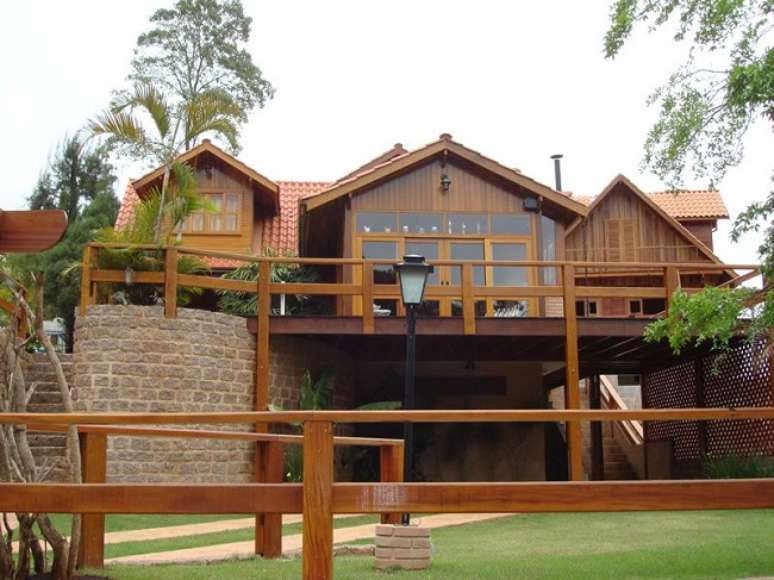 49. Lumin&aacute;rias met&aacute;licas e revestimento externo em madeira e pedra trazem charme para a fachada. Fonte: Revista Viva Decora