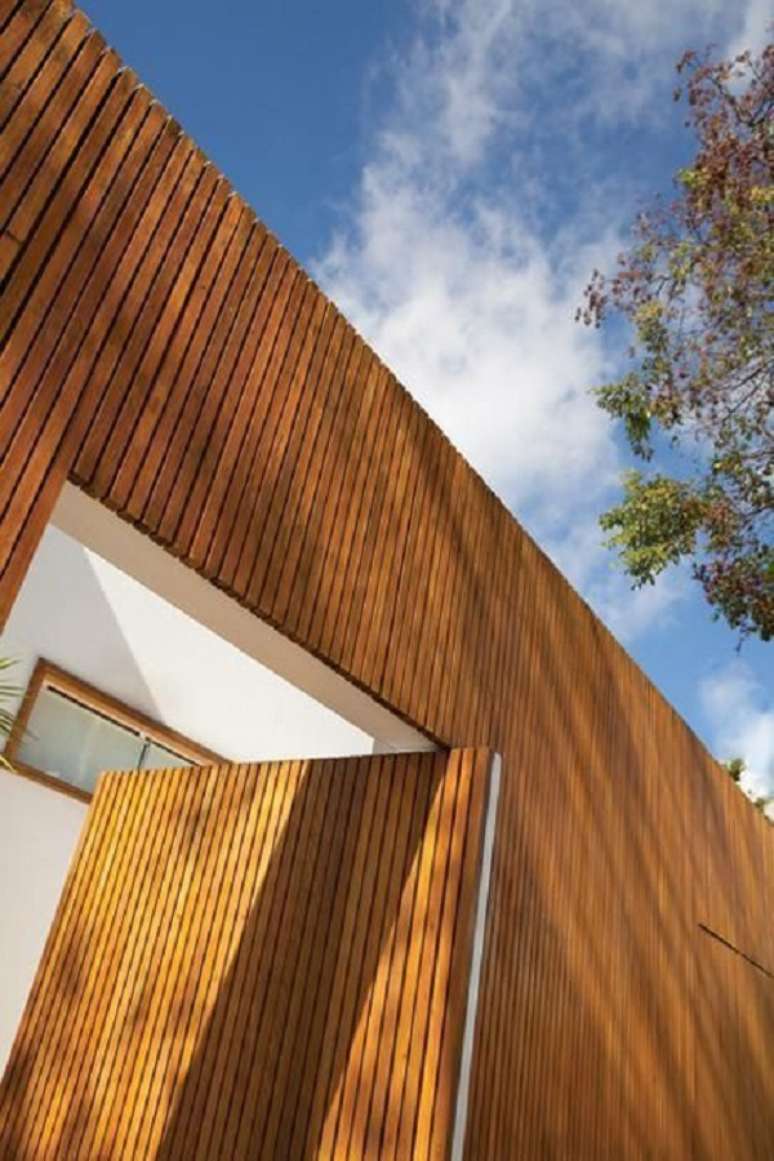 42. Fachada r&uacute;stica com revestimento externo de madeira. Projeto de Francisco Calio