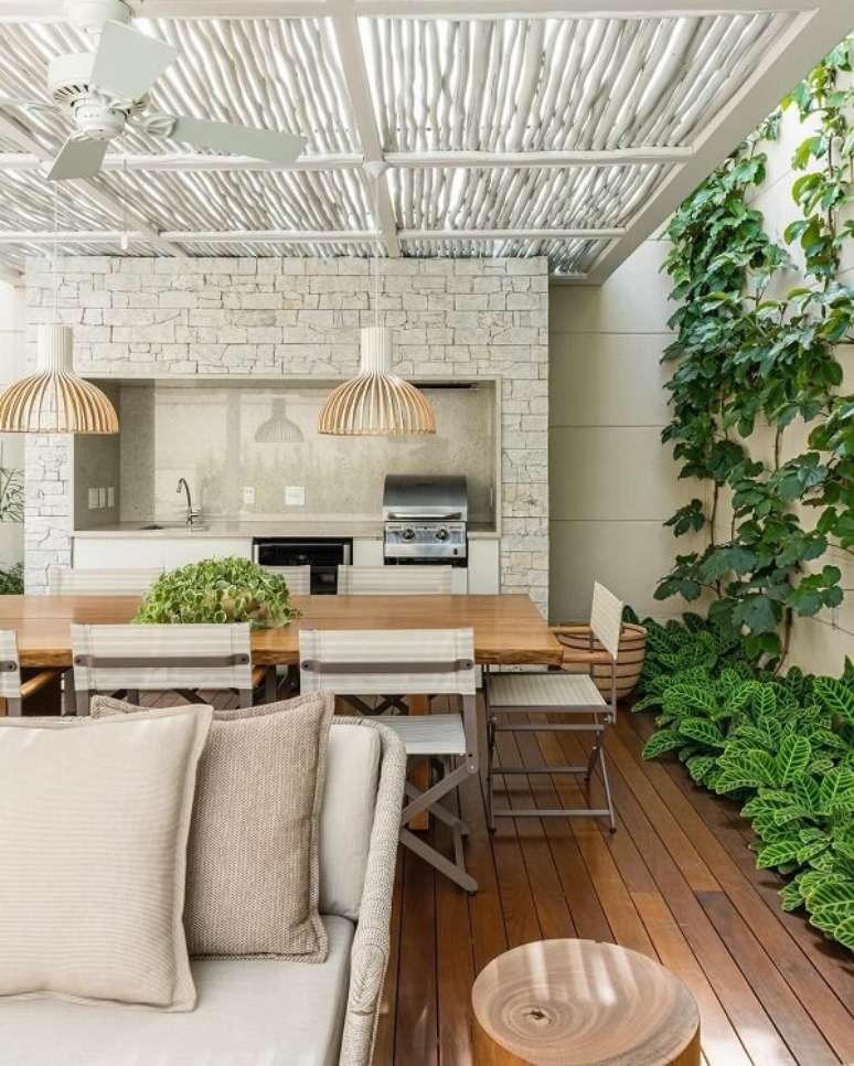 10. As pedras naturais s&atilde;o muito usadas como revestimento para &aacute;rea gourmet externa. Projeto de Triart Arquitetura