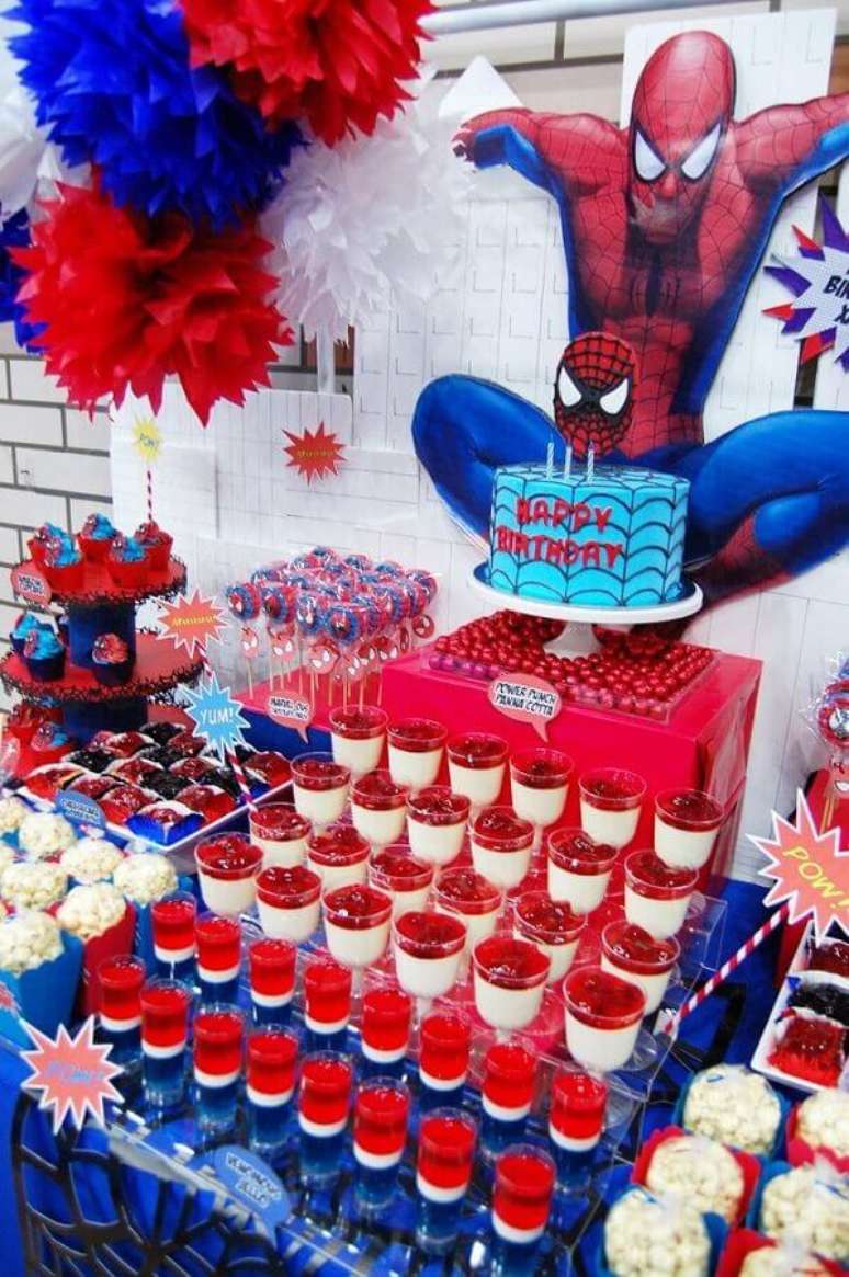 24. Decoração de mesa para festa do Homem Aranha com muitos doces e painel personalizado – Foto: Pinosy