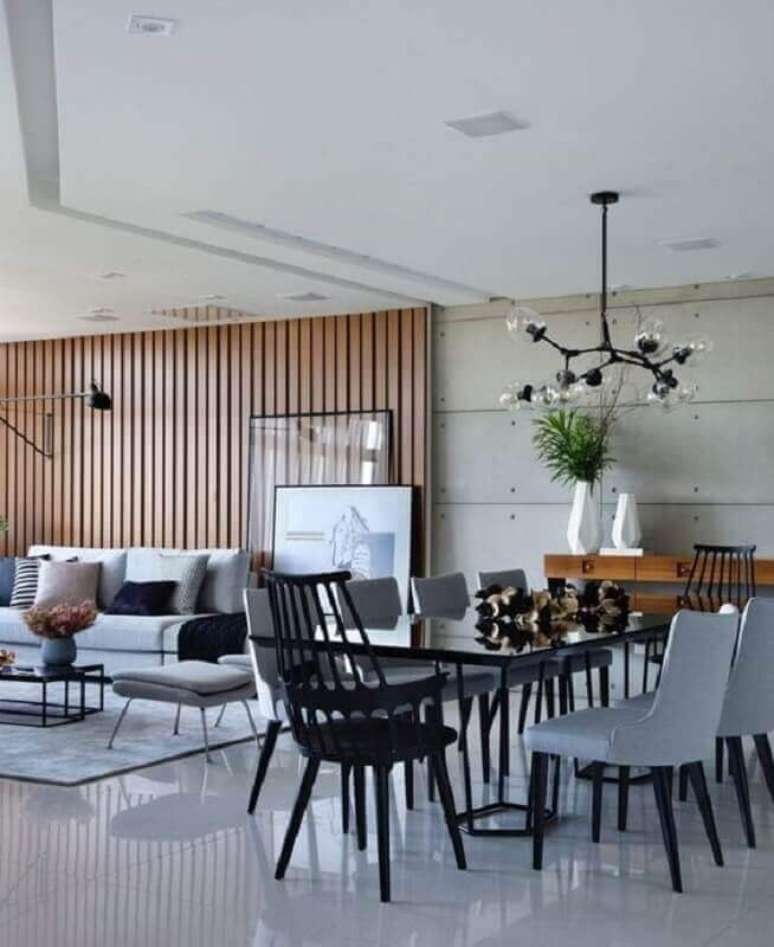 39. Sala de apartamento grande e moderno decorado em tons de cinza com painel de madeira – Foto: Futurist Architecture