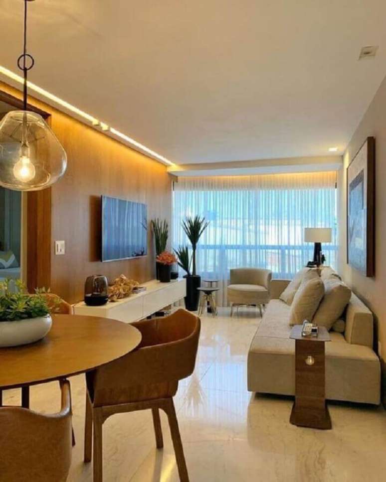 18. Decoração de sala de apartamento em cores neutras com painel de madeira para TV – Foto: Iluminim LED