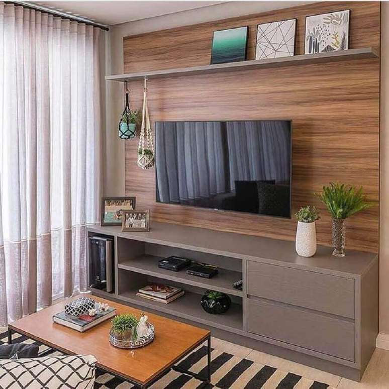 34. Painel de madeira para sala de estar apartamento decorada com rack cinza – Foto: Jeito de Casa