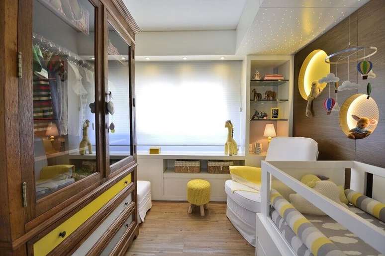 20. Decoração com nicho redondo com LED para quarto de bebê amarelo com armário de madeira – Foto: BG Arquitetura